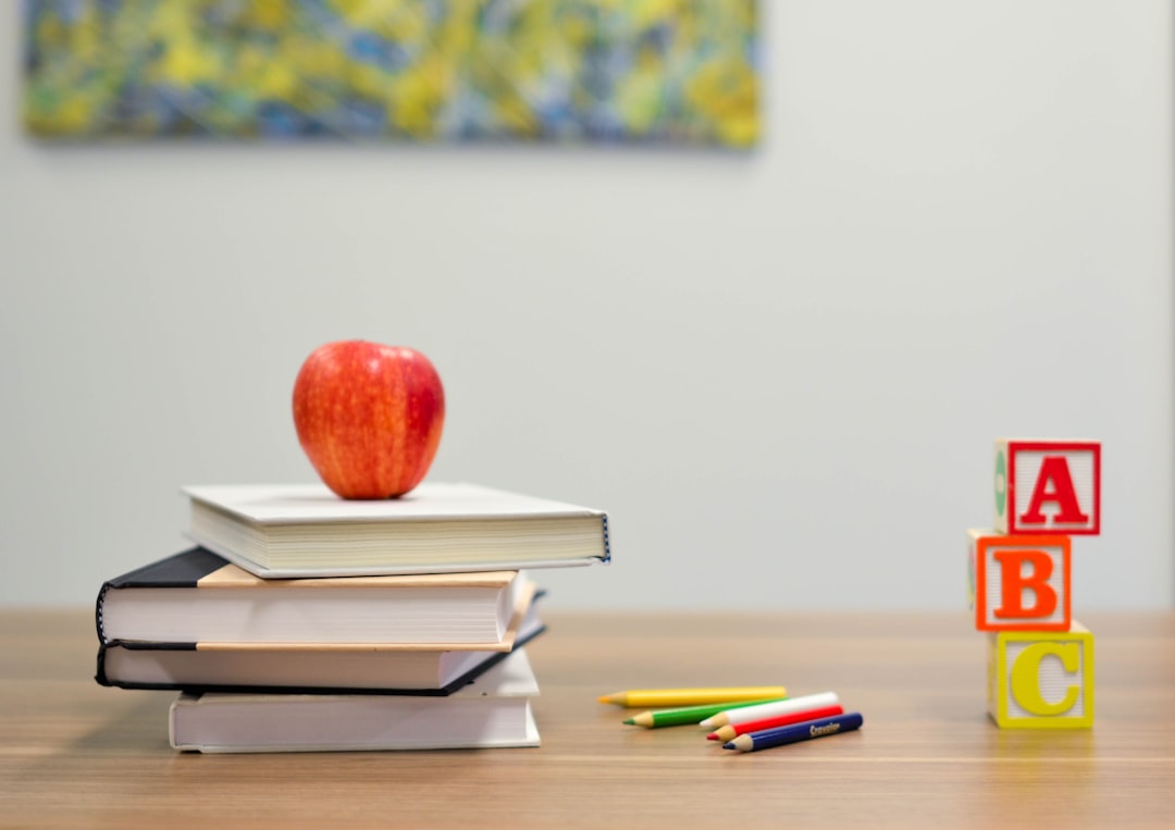 red-apple-fruit-on-four-pyle-books-oycl7y4y0bk