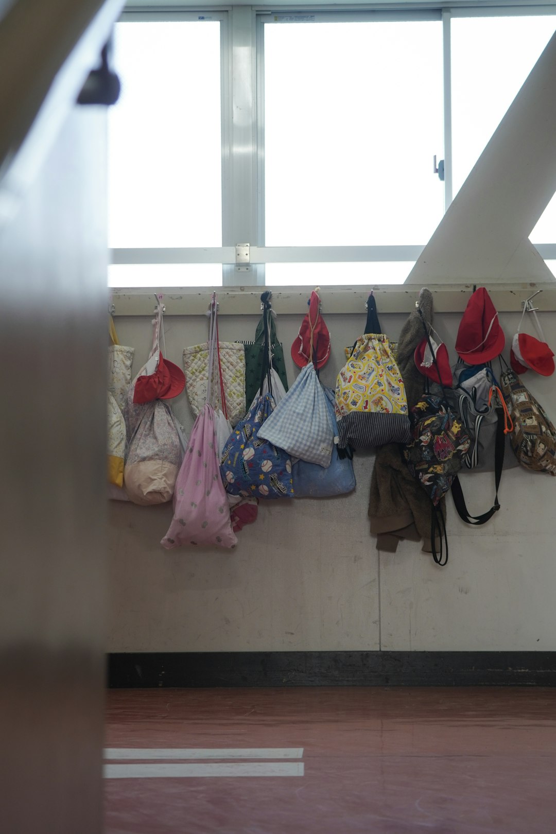 Children’s drawstring bags hanging in a school hallway